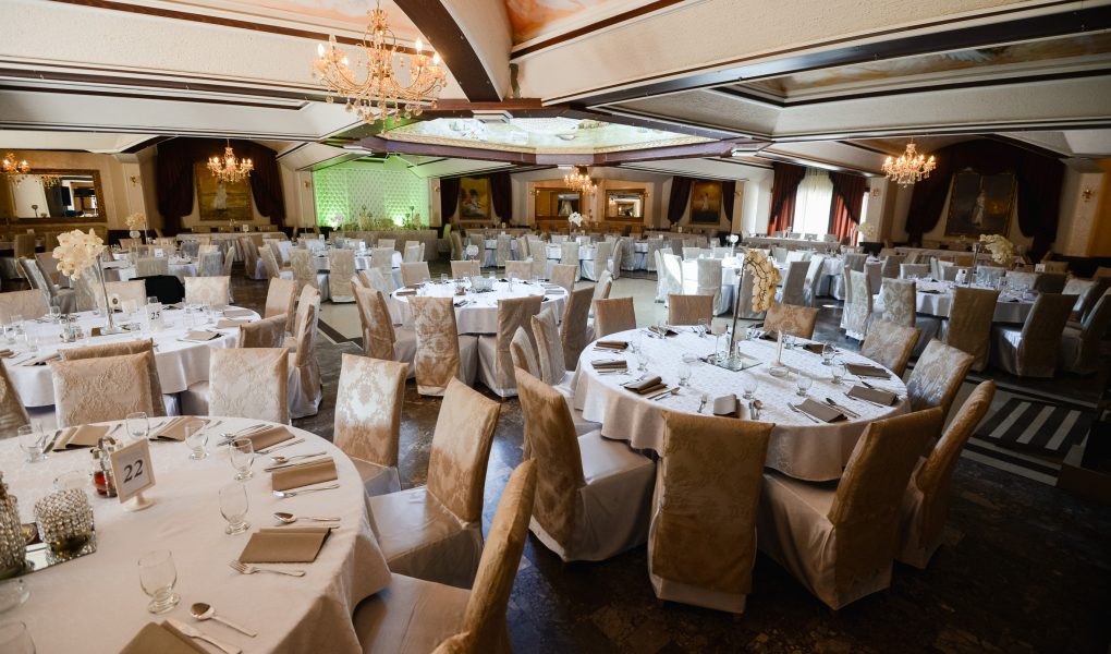 Salle de réception dressée pour un mariage, tables décorées – location de salle en Belgique