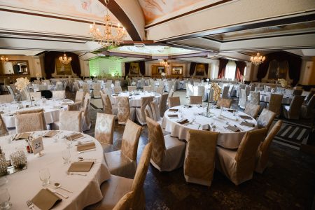 Salle de réception dressée pour un mariage, tables décorées – location de salle en Belgique