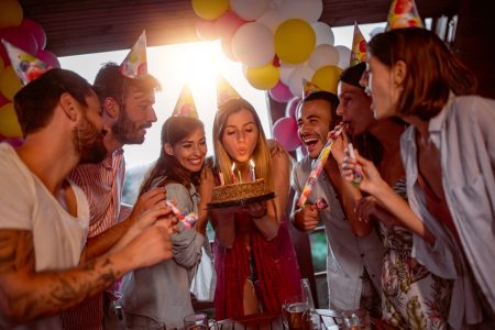 Groupe d'amis fêtant un anniversaire ensemble dans une salle