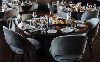 Table ronde dressée dans une salle de réception prête à accueillir les invités
