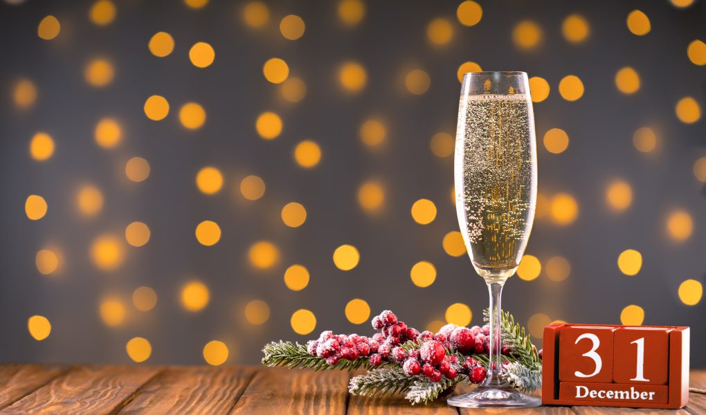 Coupe de champagne devant des lumières scintillantes pour le réveillon du 31 décembre