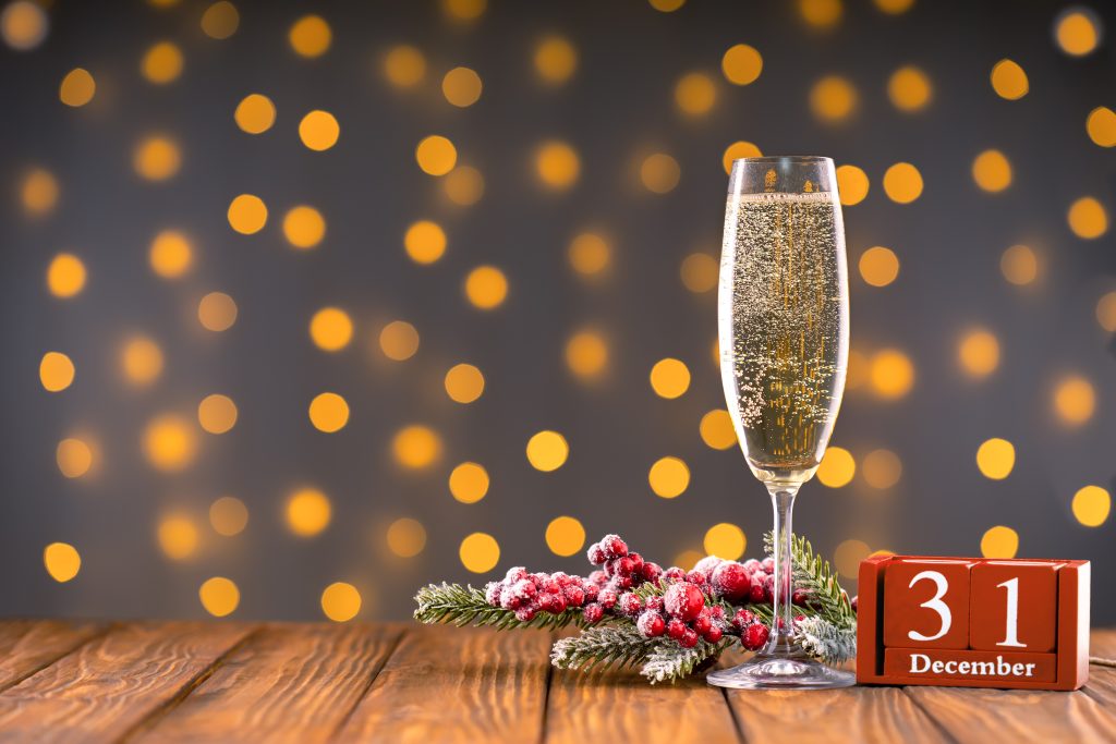 Coupe de champagne devant des lumières scintillantes pour le réveillon du 31 décembre